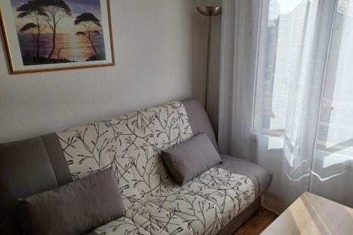 een woonkamer met een bank en een raam bij Charming studio 2 in Fréjus close to the beaches in Fréjus