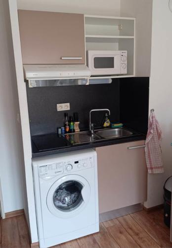 een keuken met een wasmachine en een wastafel bij Charming studio 2 in Fréjus close to the beaches in Fréjus