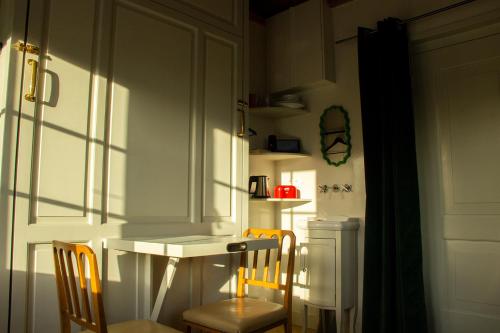 a kitchen with a table and two chairs and a white table and chairsearcher at SWEETS - Walter Süskindbrug in Amsterdam