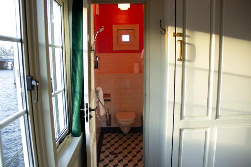 een badkamer met een toilet naast een deur bij SWEETS Walter Süskindbrug in Amsterdam
