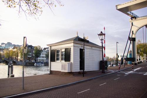 a small white building on the side of a river at SWEETS - Walter Süskindbrug in Amsterdam