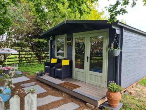 a small shed with a porch and a couch at Mulberry Cottage Farm in Wyboston