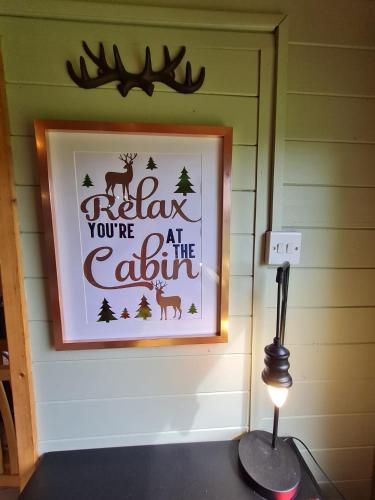 a picture of a sign that says relax youre at the cabin at Mulberry Cottage Farm in Wyboston