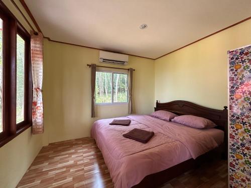 una camera da letto con un letto con lenzuola rosa e una finestra di 2 Bed Sunset Seaview Good View House B a Ko Yao Noi