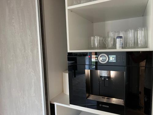 a kitchen with a black microwave in a cabinet at Fabulous Penthouse Lakeview W20 in Bucharest