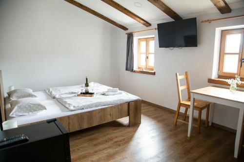 a bedroom with a bed and a desk and a tv at Boutique Rooms & Winery Žorž in Vipava