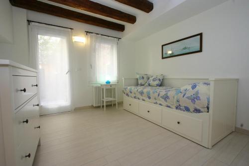 a white bedroom with a bed and a window at City Apartments Salute-Accademia in Venice