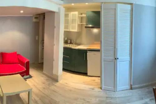 un salon avec un canapé rouge et une cuisine dans l'établissement Grand studio centre Cannes, à Cannes