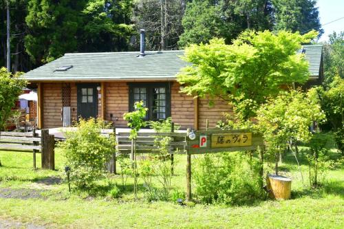 a small log cabin with a sign in front of it at 藤のヴィラ パイン棟 Self Check-in in Aso
