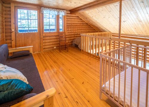 Habitación con suelo de madera y escaleras en una cabaña de madera. en Villa Tuulahdus, Sorjosen lomamökit en Savonlinna