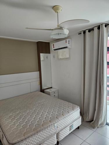 a bedroom with a bed and a ceiling fan at Bacutia Frente Mar in Guarapari