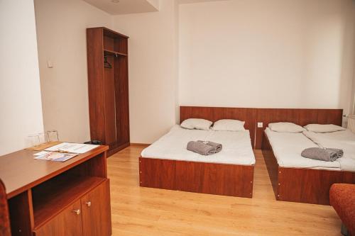 a room with two beds and a desk and a desk at Romeo&Julia in Toruń
