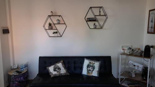 a living room with a black couch and some pictures on the wall at Casa Sabry in Olbia