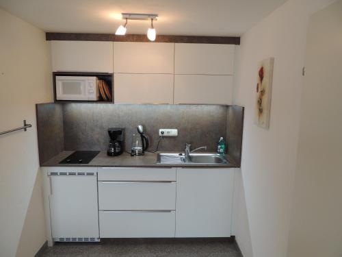 a small kitchen with a sink and a microwave at Ferienwohnungen Schöbringer in Weyregg