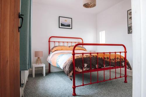 a red bed in a bedroom with a red frame at Albion Cottage central Falmouth with parking and 10 minutes to the beach in Falmouth