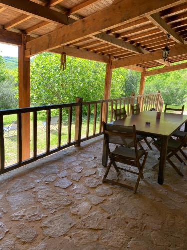 a patio with a table and chairs on a deck at Les orchidées in Saint-Cybranet