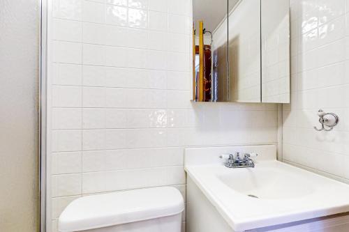 een witte badkamer met een wastafel en een toilet bij Hidden Gem in Cavendish
