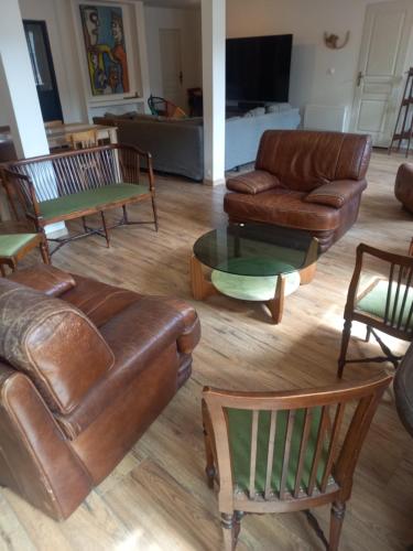 a living room with leather couches and tables at logement entier spacieux et confortable à 1 h de Paris in Courtenay