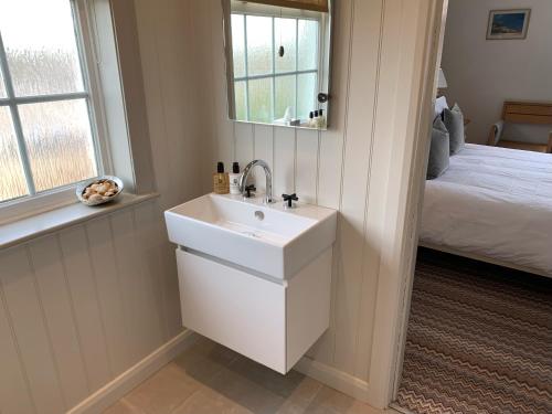 a bathroom with a white sink and a bed at The Old Bell B&B in Grimston