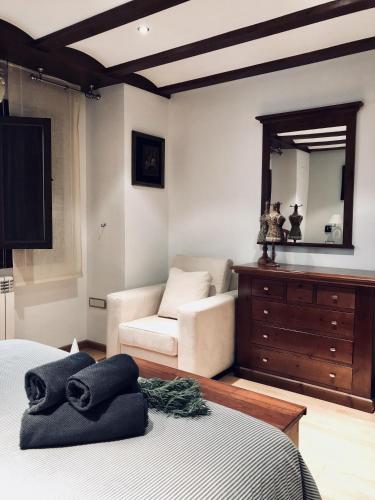 a bedroom with a bed and a dresser and a mirror at La Porticada in Morella