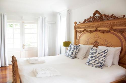 una camera da letto con un grande letto bianco con cuscini blu e bianchi di Hummingbird a Saint James