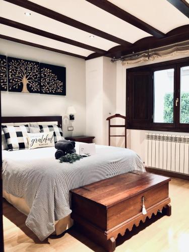 a bedroom with a large bed with a wooden table at La Porticada Boutique House in Morella