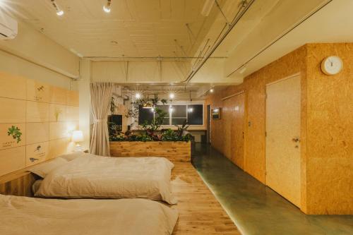 a room with two beds and a television in it at DENCHI TOKYO - Guest House DENCHI in Tokyo