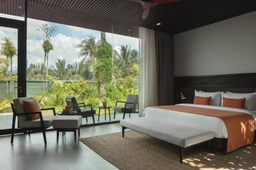 a bedroom with a large bed and a large window at Amber Kampot in Kampot