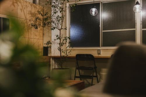 a chair sitting in front of a window with a plant at DENCHI TOKYO - Private Designer Stay in Asakusa in Tokyo