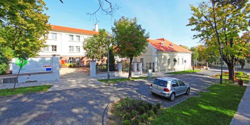 a car parked in a parking lot in front of a building at Hotel Blaha Lujza in Balatonfüred
