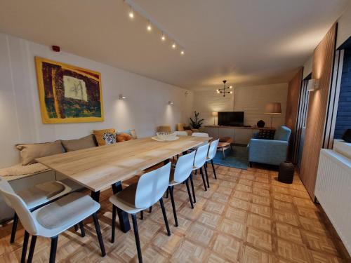 a living room with a large wooden table and chairs at Villa Op de Voort (XL, 12-22 personen) in Heusden - Zolder