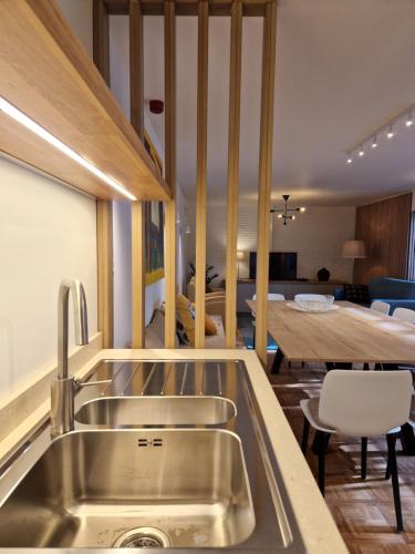 une cuisine avec un évier en acier inoxydable et une table dans l'établissement Villa Op de Voort (XL, 12-22 personen), à Heusden-Zolder