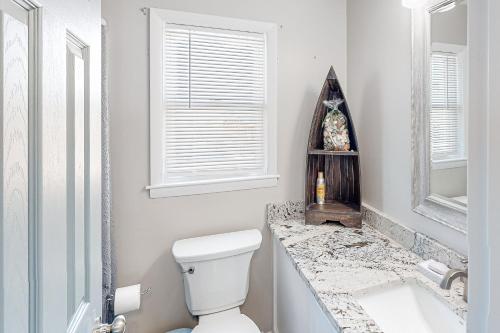 a white bathroom with a toilet and a sink at HB261 Rosie's Rendezvous in Holden Beach