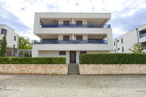 a large white building with stairs in front of it at Luxury apartments Aronia in Vantačići