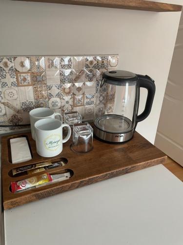 Mimoza Guesthouse في إسطنبول: طاولة مطبخ مع آلة صنع القهوة على رف خشبي
