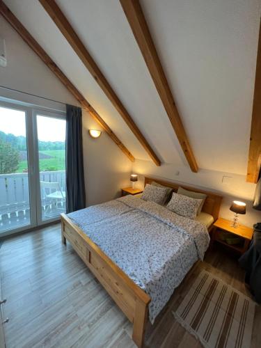 um quarto com uma cama e uma grande janela em Apartments and Rooms Kristina em Drežnik Grad