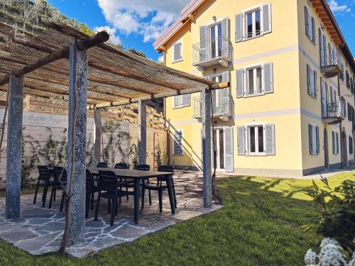 a patio with a table and chairs in front of a building at RIAREL- Foresteria Lombarda in Rodero