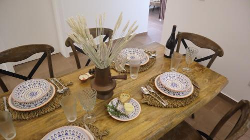 a wooden table with plates and glasses on it at Casa do Marquês in Vidigueira