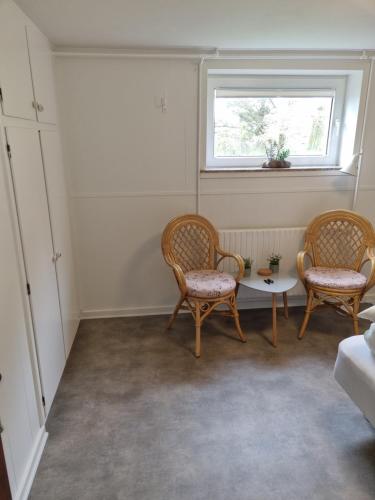um quarto com duas cadeiras, uma mesa e uma janela em Feriehuse Hvide Sande em Hvide Sande