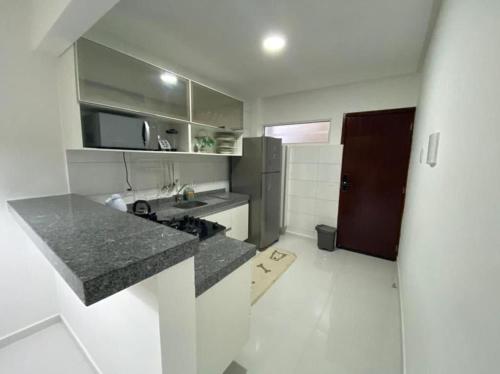 eine Küche mit einer Theke, einer Spüle und einem Kühlschrank in der Unterkunft Apartamento na Massagueira, 3km Praia do Francês in Marechal Deodoro