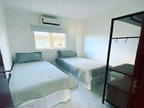 a bedroom with two beds and a mirror at Apartamento na Massagueira, 3km Praia do Francês in Marechal Deodoro