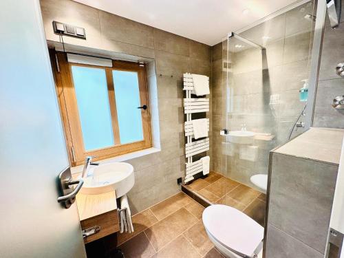 uma casa de banho com um lavatório, um WC e um chuveiro em Hotel Alte Post em Oberammergau