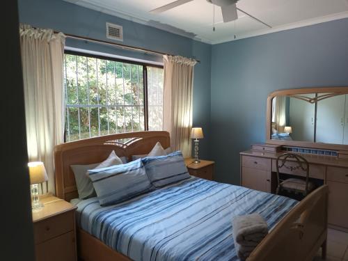 Schlafzimmer mit einem Bett mit einem Spiegel und einem Fenster in der Unterkunft Turtleshaven in St Lucia