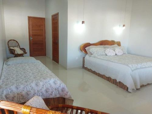 - une chambre avec deux lits et une chaise dans l'établissement Casa Viva Milagres, PX ao Réveillon dos Milagres, à São Miguel dos Milagres