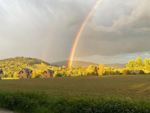 a rainbow in the sky over a field at Apartamenty MERRI in Lądek-Zdrój