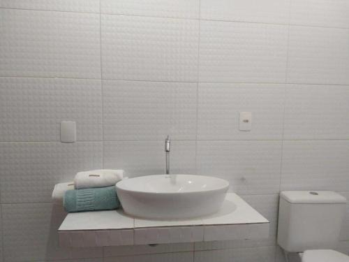 Baño blanco con lavabo y aseo en Casa Viva Milagres, PX ao Réveillon dos Milagres, en São Miguel dos Milagres