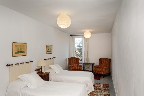 a room with two beds and two chairs at Hotel Rural Costa del Trigo in Segovia