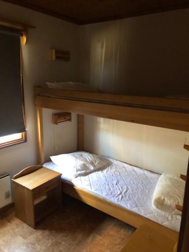 a bedroom with two bunk beds and a desk at Föllingen stugan in Kisa