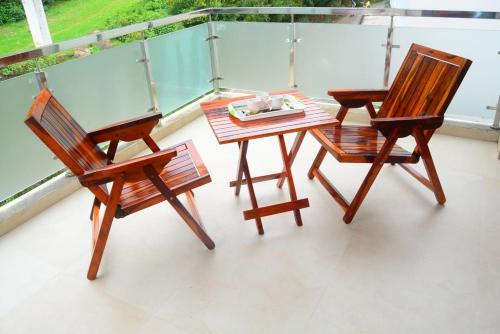 two chairs and a table on a balcony at Vanam Holidays in Ooty