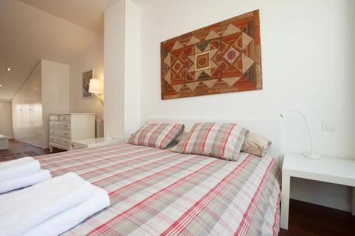 a bedroom with a bed with a plaid blanket at SingularStays Miracle in Valencia